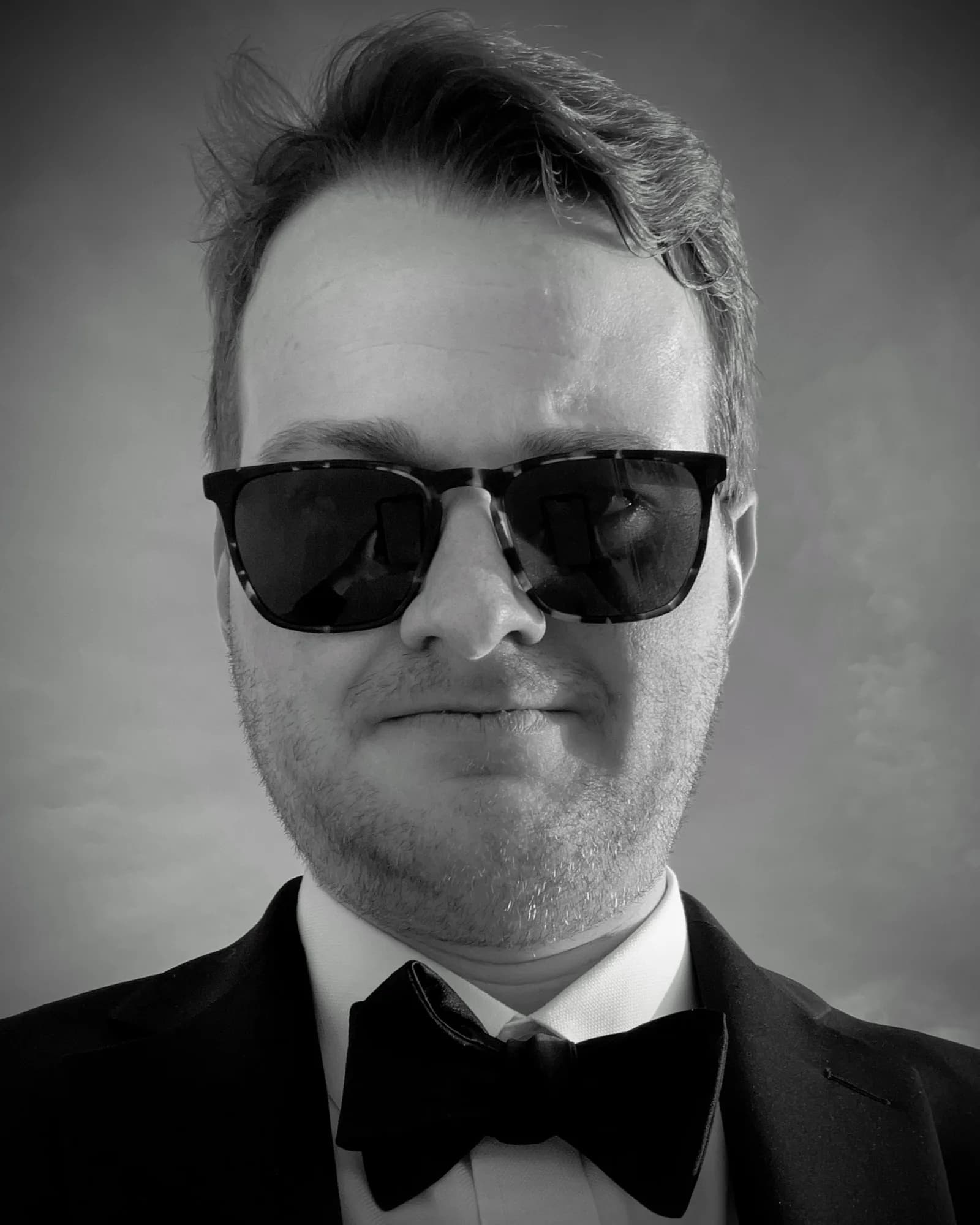 Stephen Bowman wearing sunglasses and a tuxedo